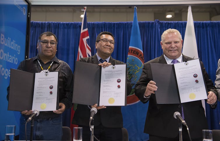 Ontario Premier Doug Ford, right, Chief Cornelius Wabasse, Webequie First Nation, left, and Chief Bruce Achneepineskum, Marten Falls First Nation, centre, show off their signed agreement