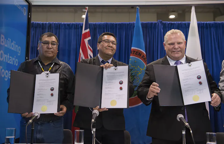 Ontario Premier Doug Ford, right, Chief Cornelius Wabasse, Webequie First Nation, left, and Chief Bruce Achneepineskum, Marten Falls First Nation, centre, show off their signed agreement