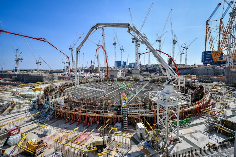 Lots of cranes surround a construction site.