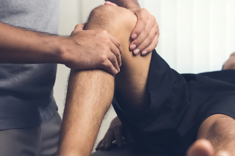 A health-care worker treating a patient's knee