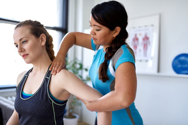 A health worker helping a patient's shoulder