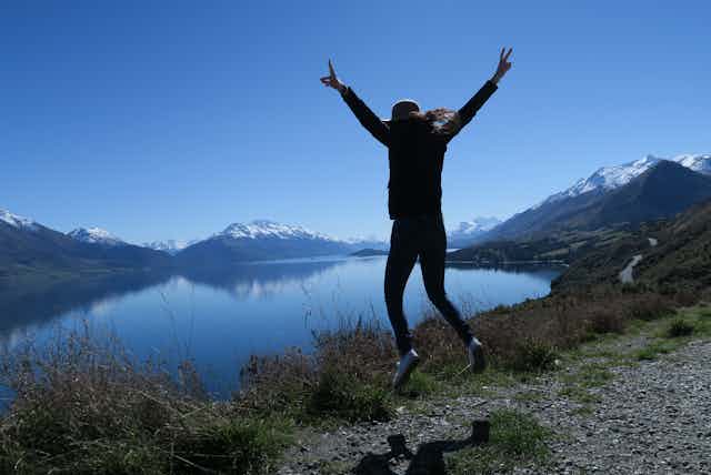 woman jumping near lake