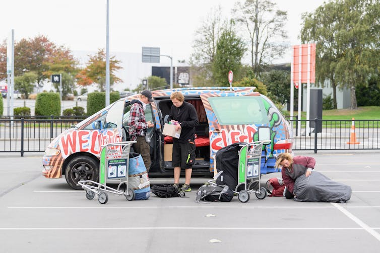 Backpackers unloading a van