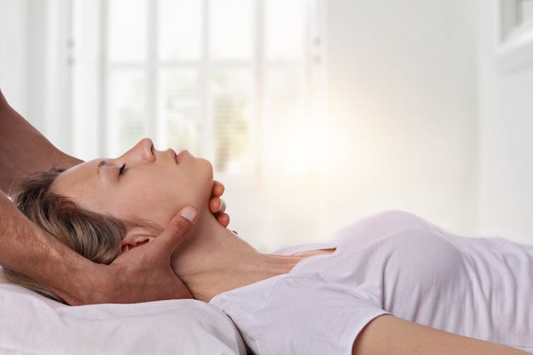 A patient receiving neck manipulation from a chiropractor