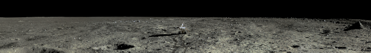 Lunar rover on the rocky cratered surface of the Moon.