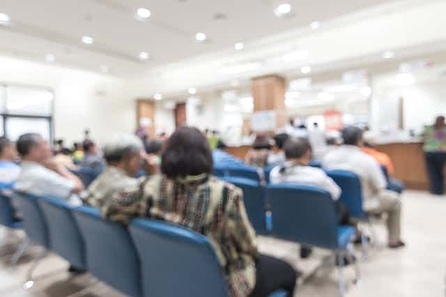 A blurred image of patients in a waiting room.