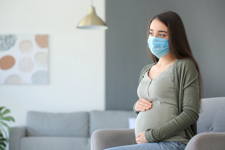 Mujer embarazada con mascarilla.