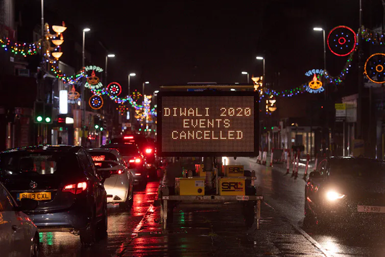 A sign on a nighttime highstreet saying 'Diwali 2020 Events Cancelled'