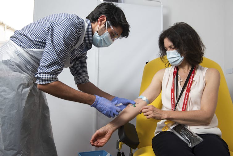 A woman receives a jab.