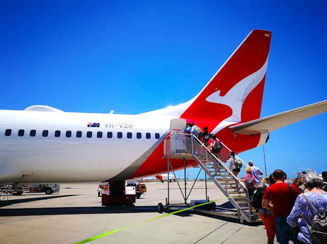 Passengers board a Qantas plane