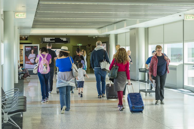 Passengers walk into an airport