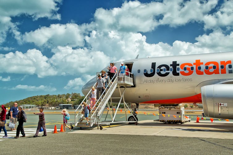 People board a Jetstar flight.