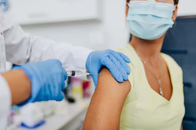 A woman receives a vaccination.