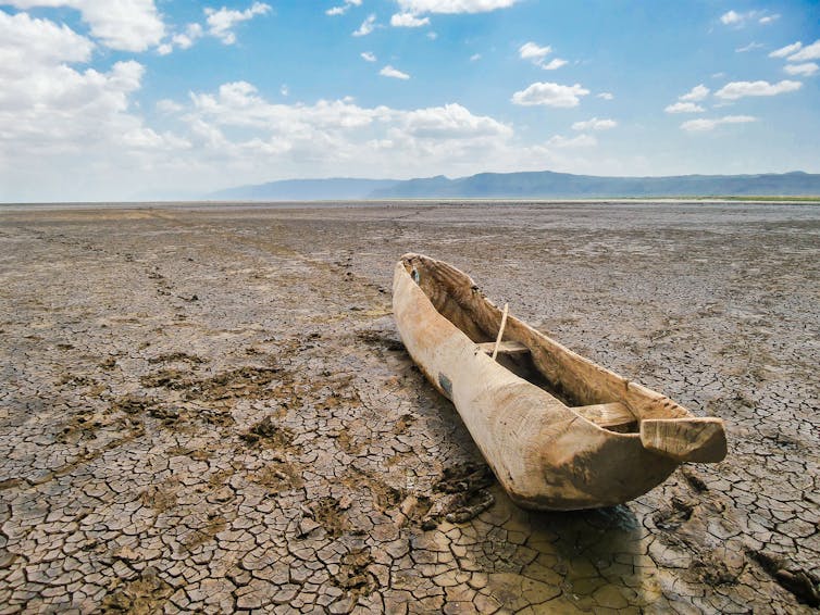 An old wooden fishing boat on a dried up river bed.