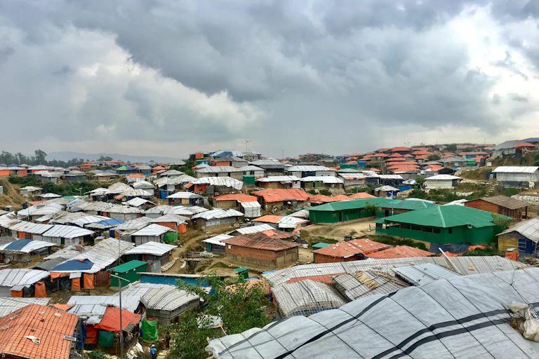 View of many makeshift coloured buildings under grey sky.
