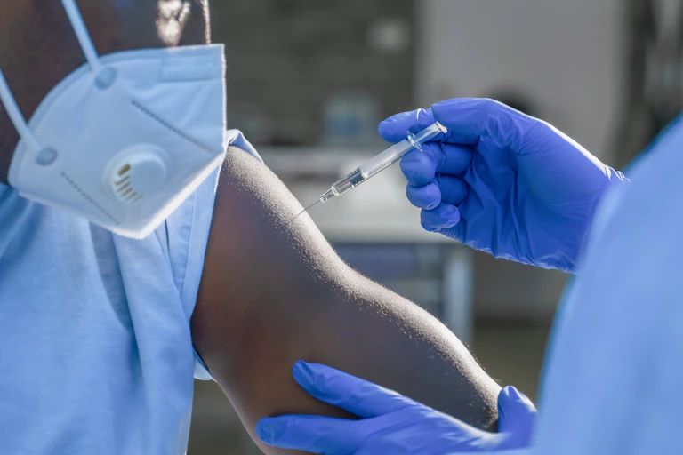 Medic injects vaccine into a man's arm.
