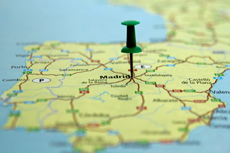 mapa de España con una chincheta verde pinchada en Madrid.