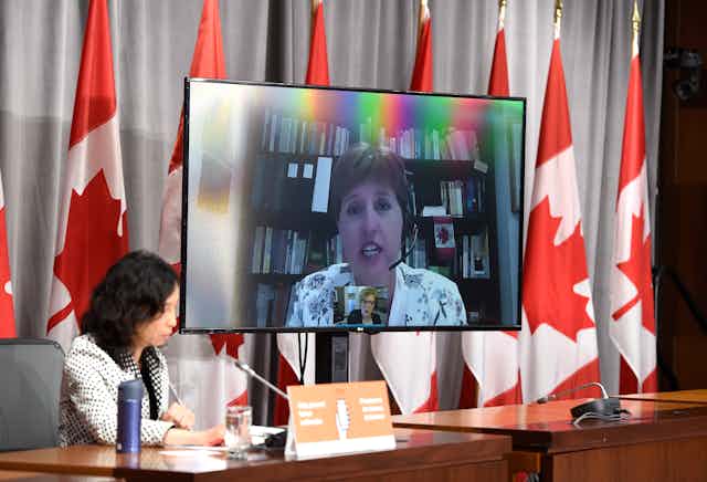 Marie-Claude Bibeau is seen on a videoconference display as Dr. Theresa Tam listens