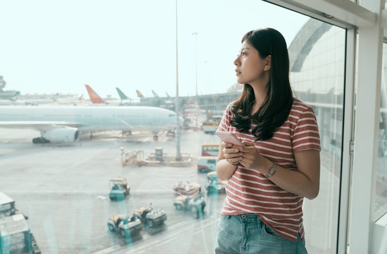 Young Chinese women looks out of airport window