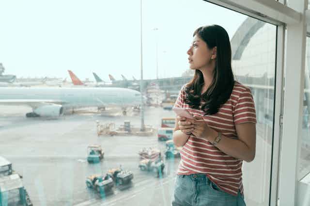 Young Chinese women looks out of airport window