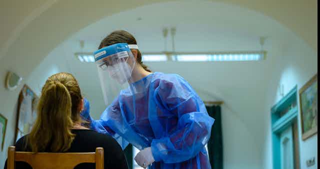 A health-care worker conducting a coronavirus test on a patient