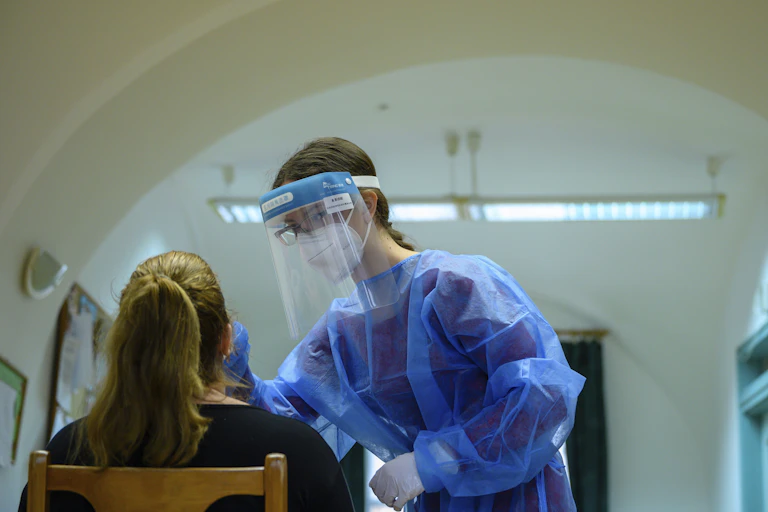 A health-care worker conducting a coronavirus test on a patient