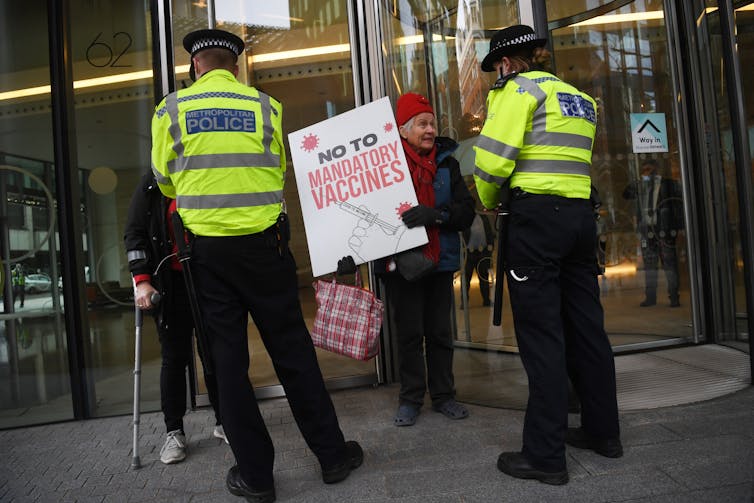 A protestor holding a sign that says: 'No to mandatory vaccines'