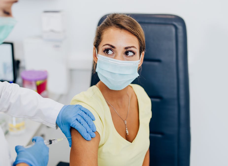 A nurse giving a woman a vaccine