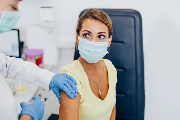 A nurse giving a woman a vaccine