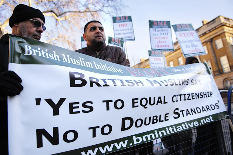 British Muslims holding banner reading 'British Muslims say yes to equal citizenship no to double standards'.
