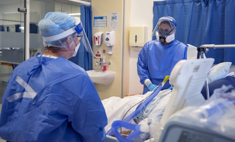 Two workers and a patient in a COVID-19 ward.