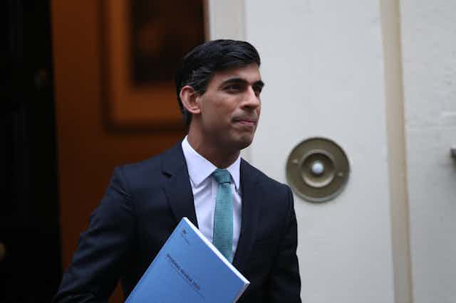 Rishi Sunak holding a copy of his 2020 spending review.