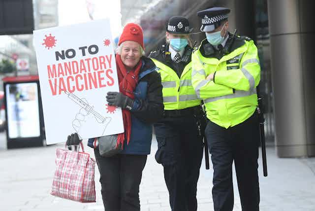 A protester in London holds a sign saying: No to mandatory vaccines.