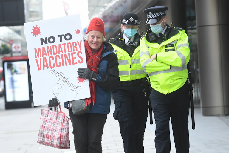 A protester in London holds a sign saying: No to mandatory vaccines.
