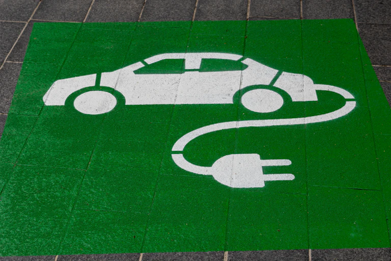 Stenciled sign on pavement of electric vehicle.