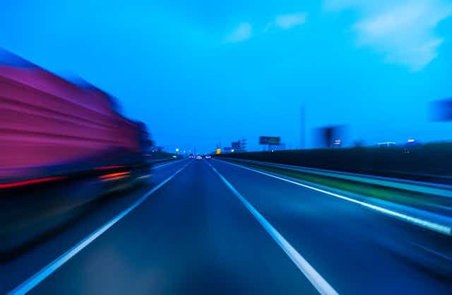Blurry truck speeding off down highway