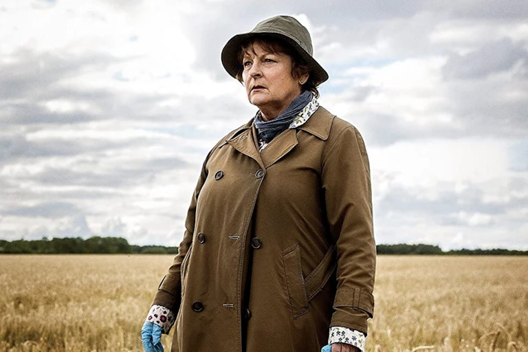 Shabbily dressed woman in field