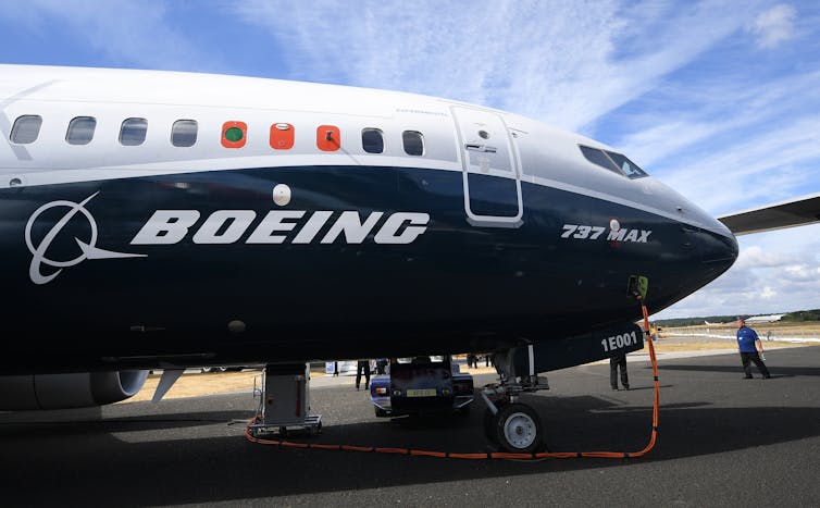 The nose of a Boeing aircraft against blue sky.