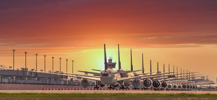 Aviones aparcados en línea durante la puesta de sol.