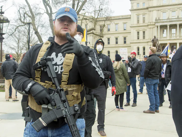 Men dressed in quasi-military outfits and carrying guns at a protest in Lansing, Michigan in April 2020.