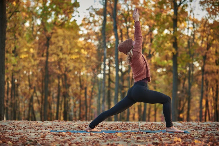 A woman doing yoga outdoors.