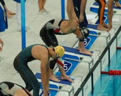 Nadadores preparando el salto a la piscina