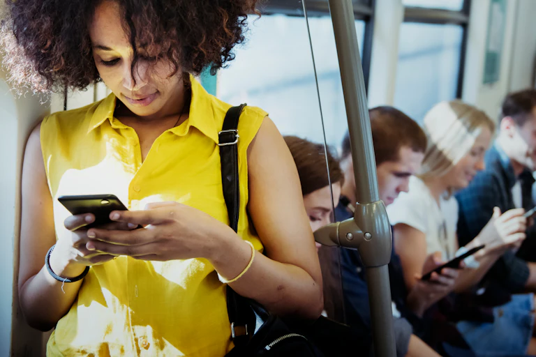 A young woman uses her smartphone on public transport.