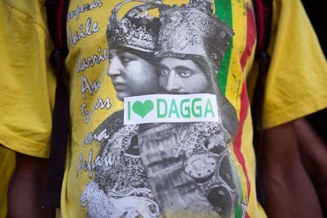A T-shirt with an image of Ethiopian rulers in black and white and a sticker in green and white across it reading, 'I love dagga'.
