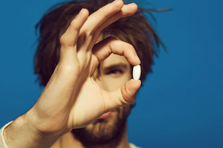 A man holding a pill