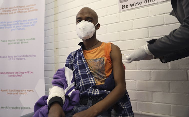 Young Black man about to receive an injection in his arm.