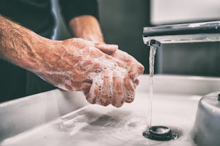 Un hombre se lava las manos con jabón.