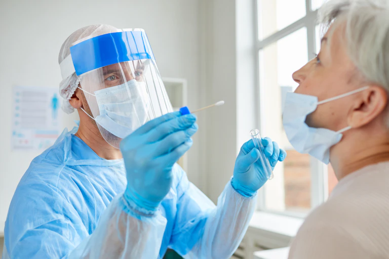 A health-care worker performs a COVID test on a woman.