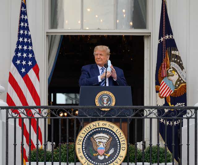 US president Donald Trump at the White House removing his mask before making an announcement.