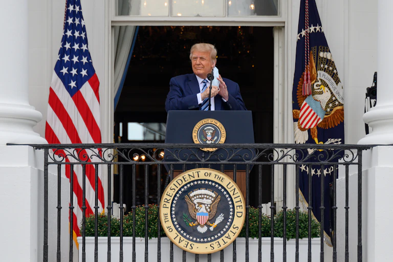 US president Donald Trump at the White House removing his mask before making an announcement.